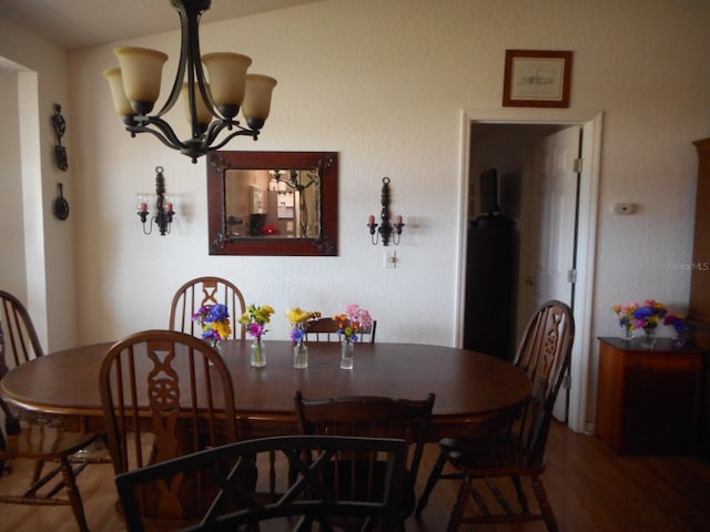 dining area featuring hardwood / wood-style flooring and a chandelier