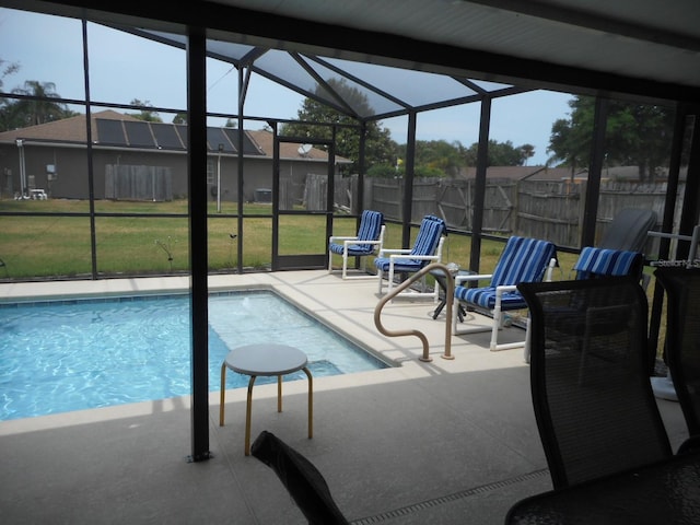 view of pool with a yard, a patio, and glass enclosure