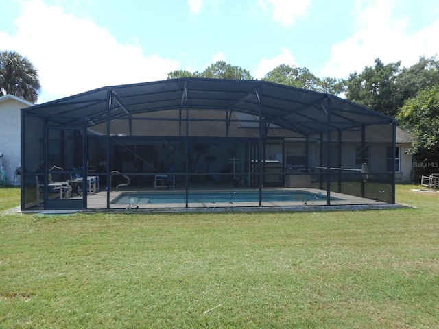 rear view of property with glass enclosure and a lawn