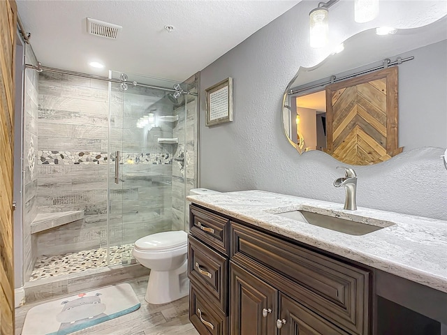 bathroom with an enclosed shower, toilet, a textured ceiling, and large vanity