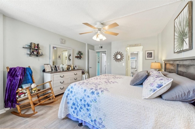 bedroom with ceiling fan, wood-type flooring, and a textured ceiling