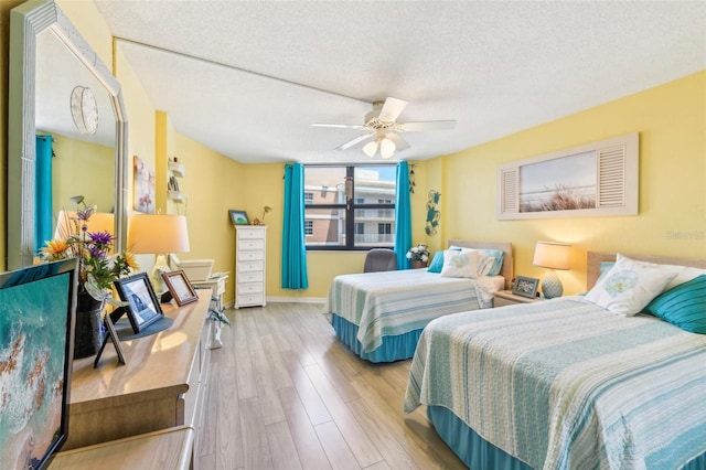 bedroom featuring a textured ceiling, light wood-type flooring, and ceiling fan