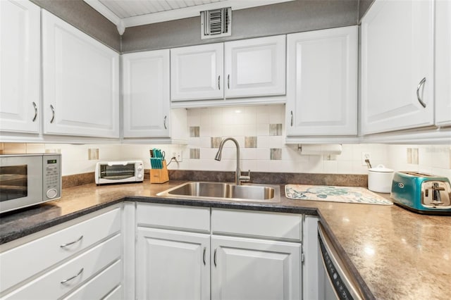 kitchen with white cabinets, dishwasher, decorative backsplash, and sink