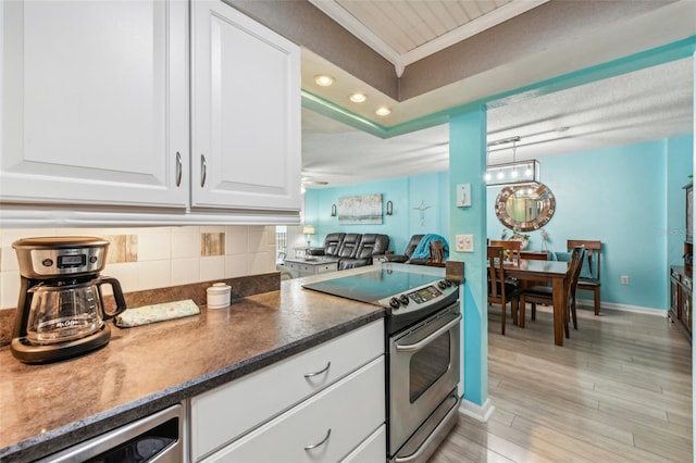 kitchen featuring decorative backsplash, ornamental molding, stainless steel appliances, light hardwood / wood-style floors, and white cabinetry