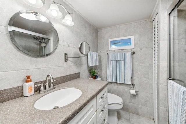 bathroom with toilet, a shower with door, vanity, tile walls, and ornamental molding