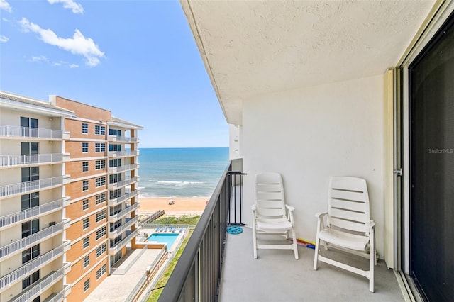 balcony with a water view and a beach view