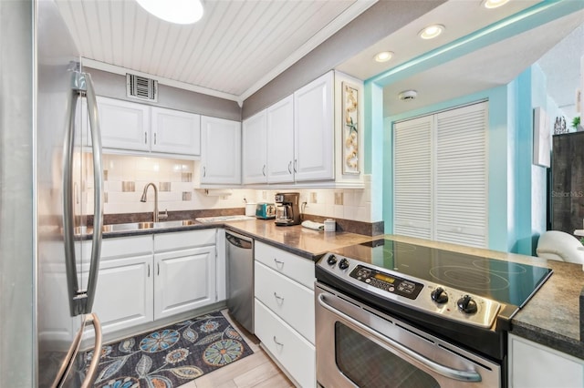 kitchen with white cabinets, sink, backsplash, and appliances with stainless steel finishes