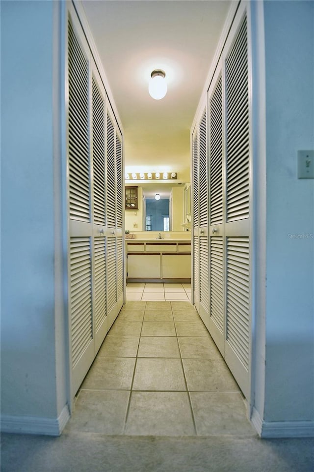 corridor featuring light tile patterned floors and baseboards