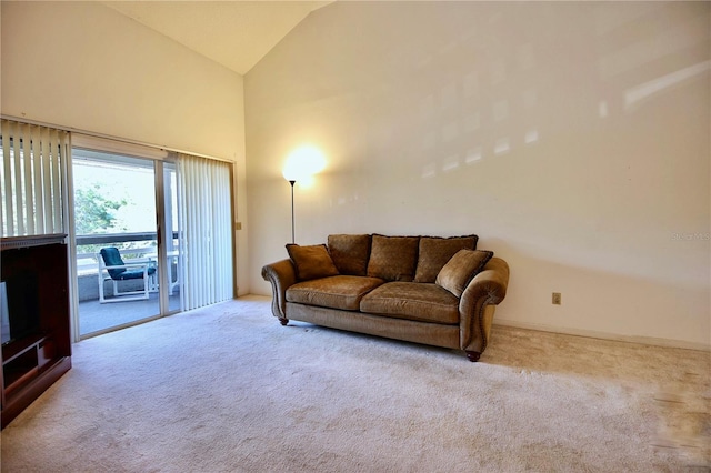 living area with high vaulted ceiling and light colored carpet