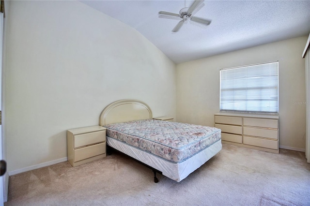 bedroom featuring lofted ceiling, a textured ceiling, baseboards, and light colored carpet