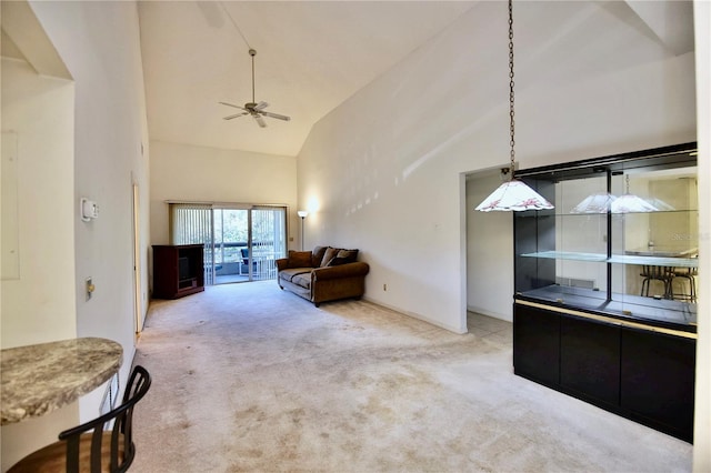 carpeted living room with baseboards, high vaulted ceiling, and a ceiling fan