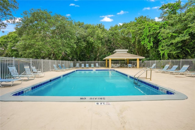 community pool featuring fence, a patio, and a gazebo