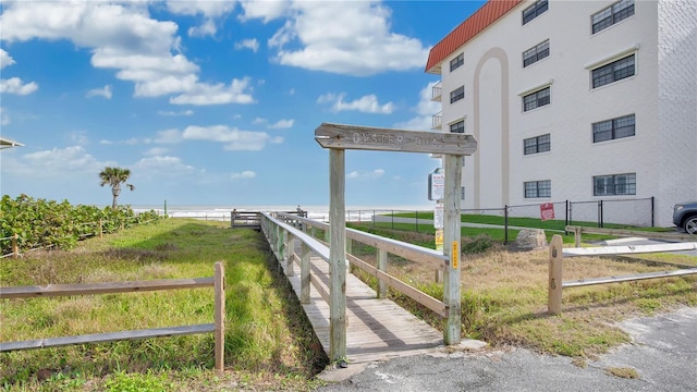 view of home's community with a water view and fence