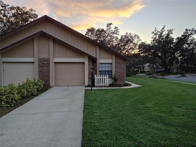 ranch-style house featuring a garage and a lawn