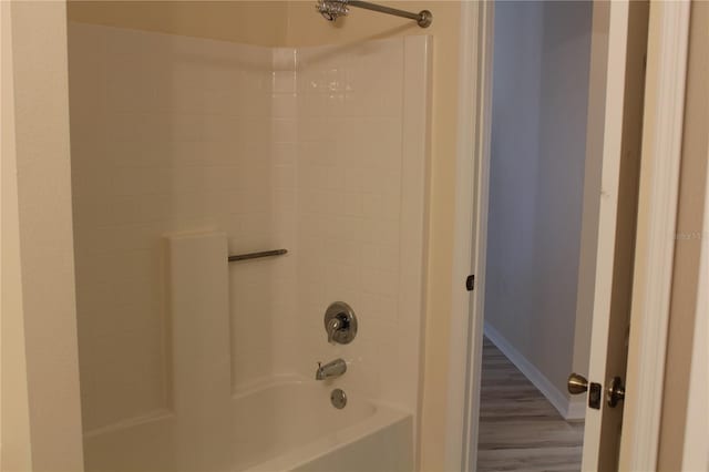 bathroom with hardwood / wood-style flooring and shower / bathtub combination