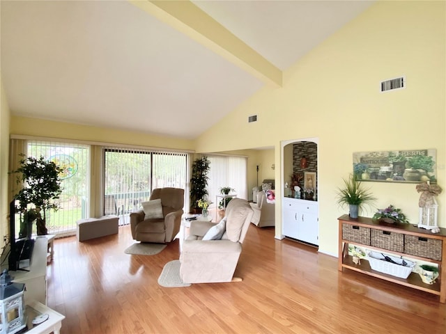 living room featuring high vaulted ceiling, beam ceiling, and light hardwood / wood-style floors