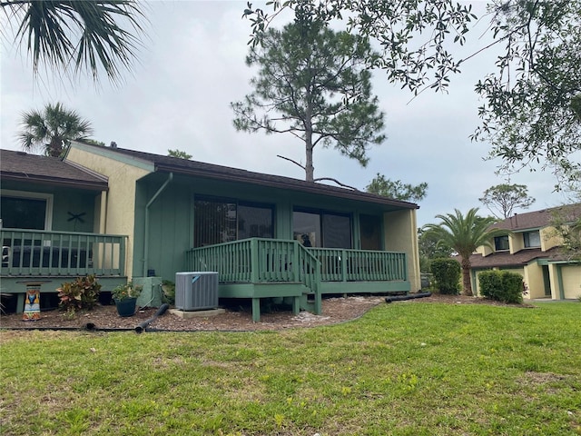 rear view of property with a yard and central AC