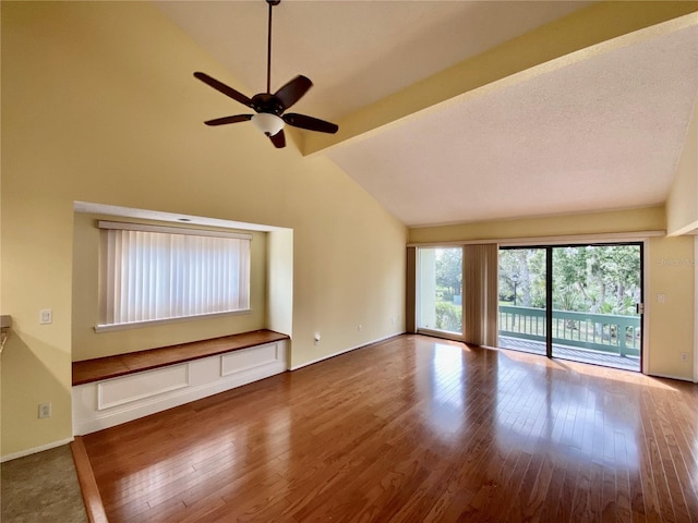 unfurnished living room featuring lofted ceiling with beams, hardwood / wood-style flooring, and ceiling fan