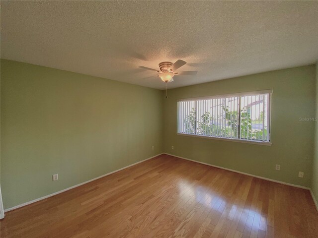 empty room featuring a textured ceiling, ceiling fan, and light hardwood / wood-style flooring