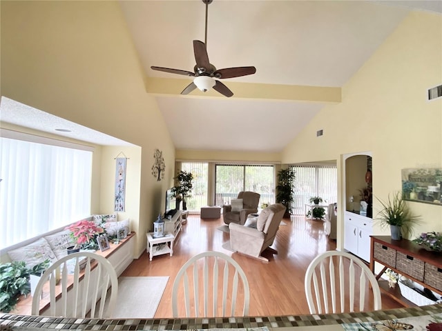 living room with wood-type flooring, high vaulted ceiling, beamed ceiling, and ceiling fan