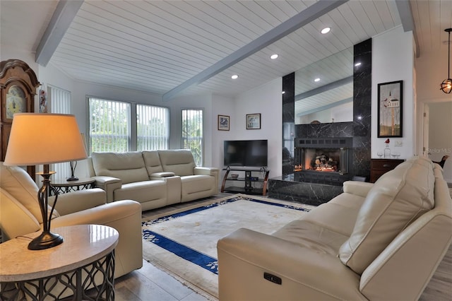 living room with light hardwood / wood-style floors, wooden ceiling, vaulted ceiling with beams, and a fireplace