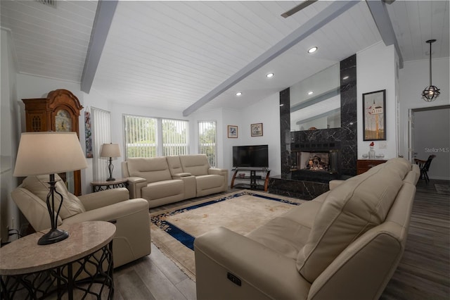 living room featuring a high end fireplace, hardwood / wood-style floors, and lofted ceiling with beams