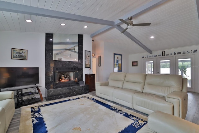 living room with a fireplace, lofted ceiling with beams, light hardwood / wood-style floors, ceiling fan, and wooden ceiling