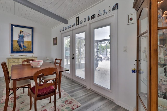 dining room featuring french doors, lofted ceiling with beams, wooden ceiling, and light wood-type flooring