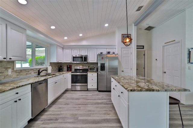 kitchen with white cabinetry, appliances with stainless steel finishes, vaulted ceiling, and sink