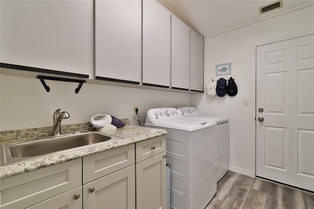 washroom featuring hardwood / wood-style flooring, wooden ceiling, sink, cabinets, and washing machine and dryer