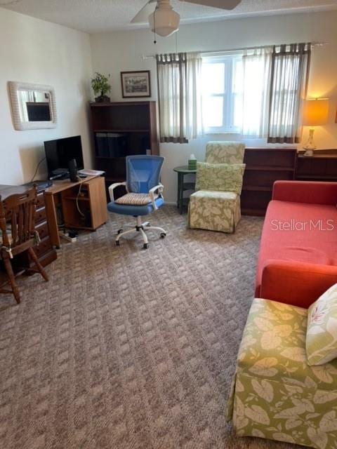 carpeted office featuring ceiling fan