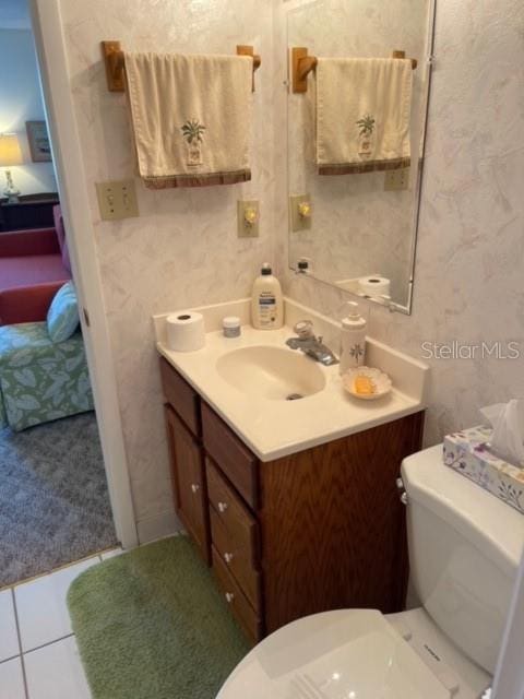 bathroom with tile flooring, vanity, and toilet