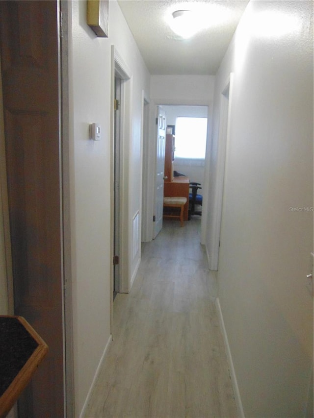 hallway with light hardwood / wood-style flooring