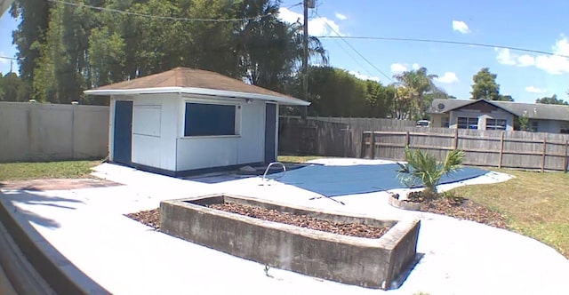 view of pool featuring a patio and a storage shed