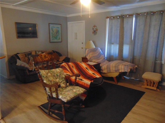 living room featuring hardwood / wood-style floors, ornamental molding, and ceiling fan