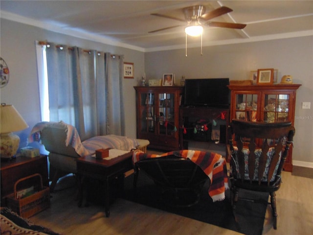 living room featuring wood-type flooring, ceiling fan, and crown molding