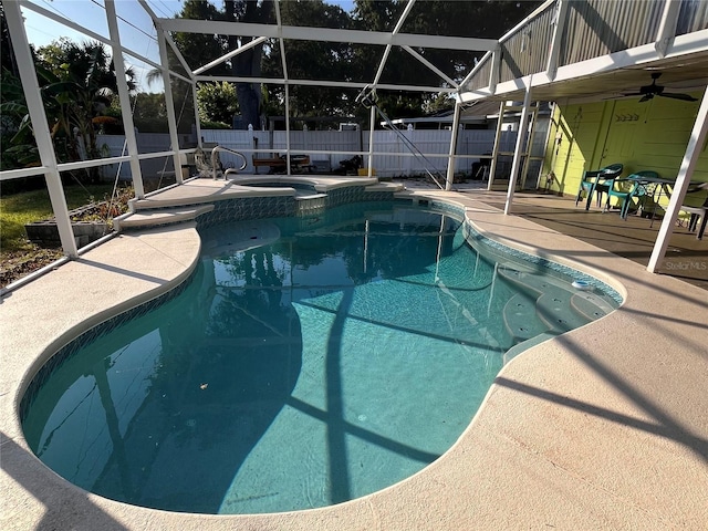 view of swimming pool featuring glass enclosure, an in ground hot tub, and a patio