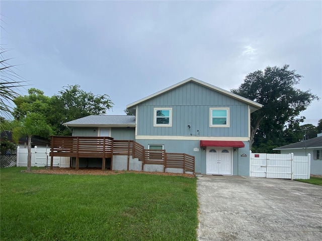 view of front of home with a wooden deck and a front lawn