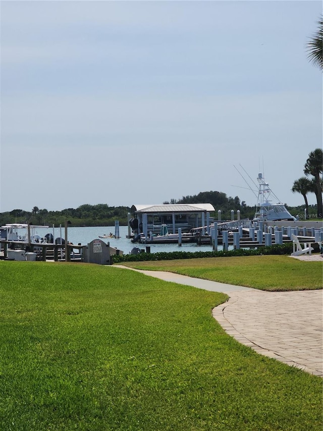 view of property's community featuring a boat dock, a water view, and a yard