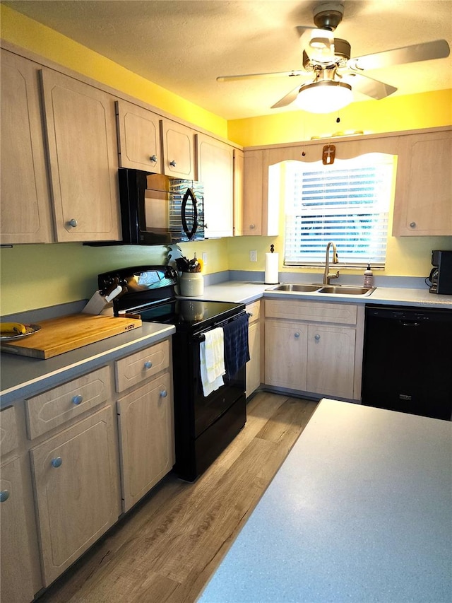 kitchen with ceiling fan, light hardwood / wood-style floors, light brown cabinetry, black appliances, and sink