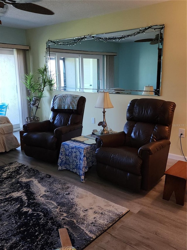 living room with ceiling fan, a healthy amount of sunlight, a textured ceiling, and wood-type flooring