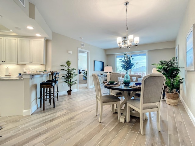 dining space featuring an inviting chandelier and light wood-type flooring