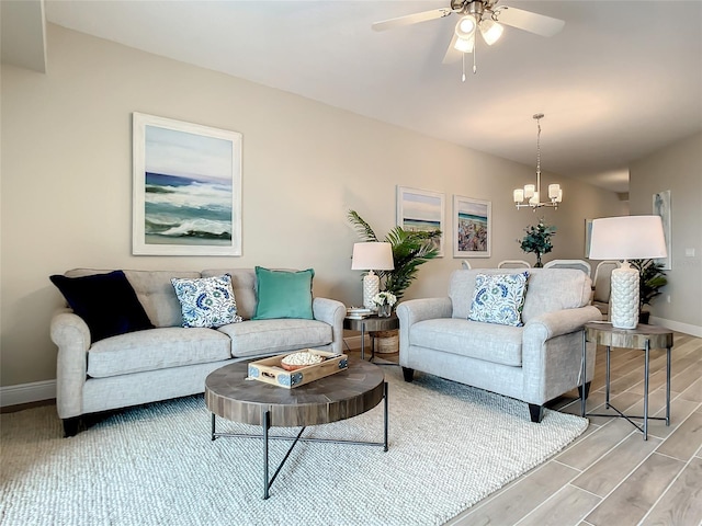 living room with hardwood / wood-style flooring and ceiling fan with notable chandelier