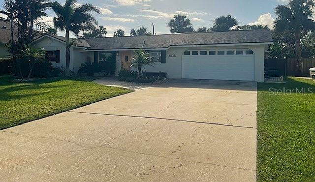 single story home with a front yard and a garage