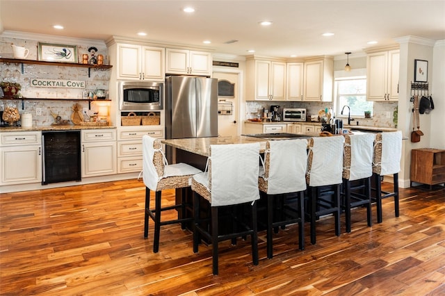 4606 Doris Dr, New Smyrna Beach, FL 32169 - kitchen with wine cooler, appliances with stainless steel finishes, ornamental molding, decorative backsplash, and light wood-style flooring