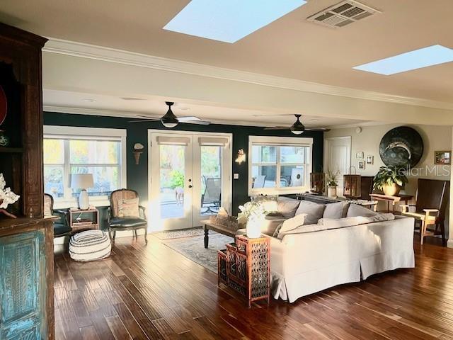 4606 Doris Dr, New Smyrna Beach, FL 32169 - living area with a skylight, a ceiling fan, wood finished floors, and ornamental molding