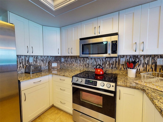 kitchen with stainless steel appliances, tasteful backsplash, and white cabinetry