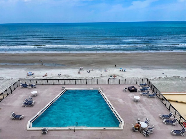 view of swimming pool featuring a beach view and a water view