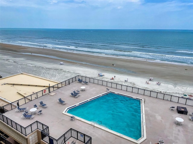 view of pool featuring a beach view and a water view