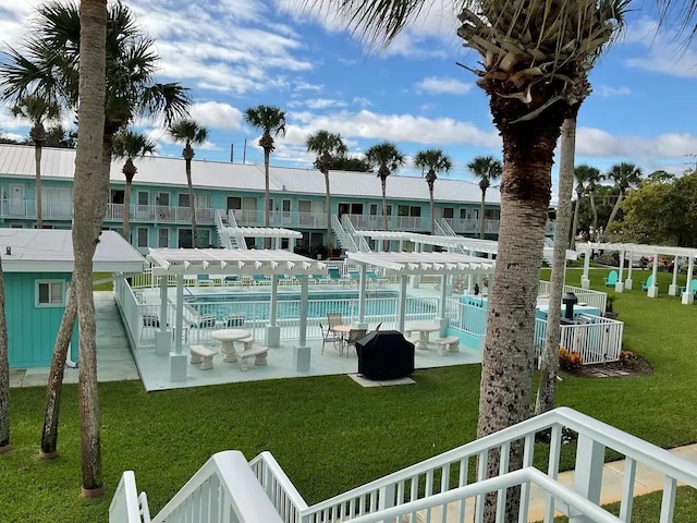 view of swimming pool featuring a lawn and a pergola